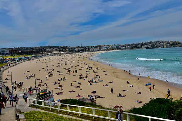 Bondi Beach Sydney with golden sand, blue ocean and surfers