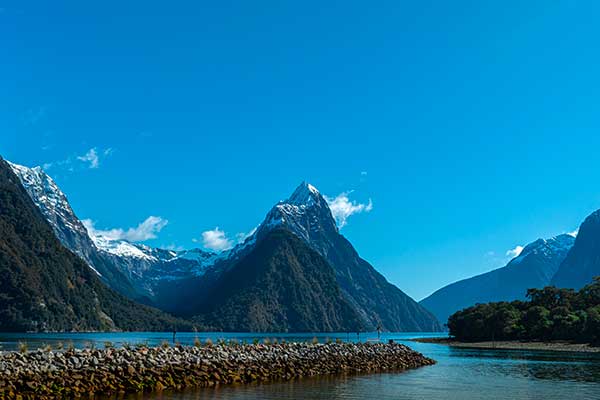 RealNZ cruise boat surrounded by mountains in Milford Sound
